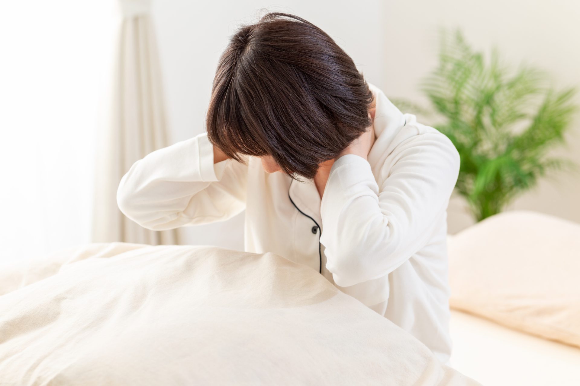 就寝時に首の後ろを押さえる女性