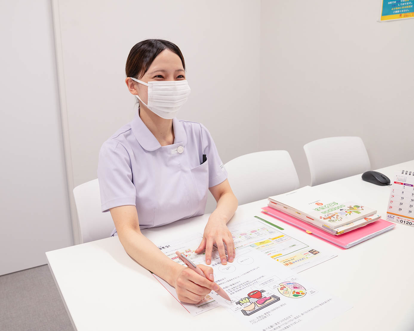資料を手に食事の説明をする管理栄養士